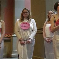 In this image taken from video, women in chains protest against child marriage, Feb. 14, 2017, at the Capitol in Albany, N.Y. Child advocates say New York's marriage law can trap minors in abuse.