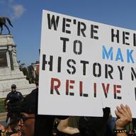 Protesters hold signs in front of the statue of Confederate General Robert E. Lee on Monument Avenue in Richmond, Va., Saturday, Sept. 16, 2017. 