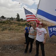 Israelis hold American and Israeli flags with the new U.S. embassy in the background in Jerusalem, Monday, May 14, 2018. Israel prepared for the festive inauguration of a new U.S. Embassy.