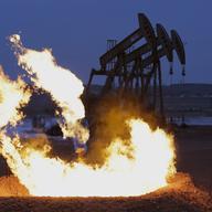 Flames erupt from a natural gas flare near oil pump jacks in the Watford City, N.D. area.