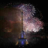 Bastille Day fireworks explode over the Seine river next to the Eiffel Tower in Paris Monday night, July 14, 2014. 
