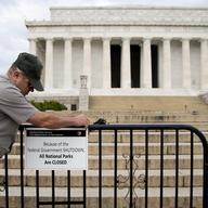 During the partial federal government shutdown in October of 2013, a National Park Service employee posts a sign on a barricade closing access to the Lincoln Memorial in Washington.