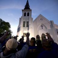AP10ThingsToSee - Members of the Omega Psi Phi Fraternity lead a crowd of people in prayer outside the Emanuel African Methodist Episcopal Church after a memorial in Charleston, S.C. on  June 19, 2015