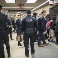 Amtrak police watch as passengers make their way to the track to board the first train to leave Penn Station after delays caused by a stuck train, Friday, April 14, 2017.