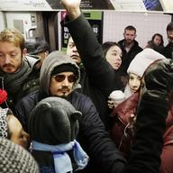 Commuter crowded on the L train as service is operating at near peak capacity.