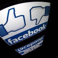 The 'Facebook' logo is seen on a tablet screen.
