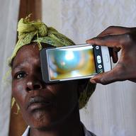 August 28, 2013: in Kianjokoma village, near Kenya's lakeside town of Naivasha, a technician scans the eye of a woman with a smartphone application.
