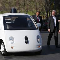 Google's Chris Urmson (R) shows a Google self-driving car to U.S. Transportation Secretary Anthony Foxx (L) and Google Chairman Eric Schmidt (C) at the Google headquarters on February 2, 2015.