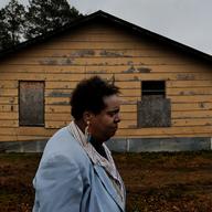 Linda Fay Engle-Harris walks a block from her home where many homes are in bad shape. Tunica County, Mississippi was once one of the poorest counties in America.
