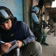 Charles Crain, a reporter working for Time Magazine, takes notes during a gun battle. January 16, 2005. Tal Afar, Iraq.