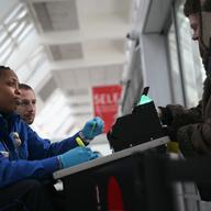  A TSA agent checks a traveler's identification at a special TSA Pre-check lane at Terminal C of the LaGuardia Airport on January 27, 2014 in New York City.
