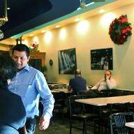 The maitre d' at Cafe Luna in Staten Island wishes Happy New Year to some regular customers.