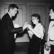 May 1958: Senator John F. Kennedy (1917-1963) helps a coed to click her pen so that he can sign her copy of his book, 'Profiles in Courage,' Portland State College (now Portland State University), Ore
