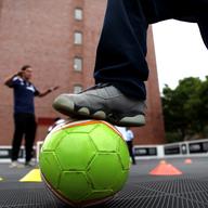 Kids from East New York, some still wearing their basketball sneakers, at soccer practice with the Street Soccer USA coaches.