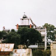 A CIA employee helps Vietnamese evacuees onto an Air America helicopter from the top of 22 Gia Long Street, a half mile from the U.S. Embassy. April 29, 1975