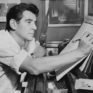 Leonard Bernstein seated at the piano in 1955.