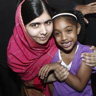 Malala Yousafzai (L) of Pakistan poses with Elizabeth Archibald at the National Academy for the Performing Arts on July 30, 2014 in Port of Spain, Trinidad.