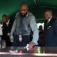 Michael Brown Sr. wipes the top of the vault during the funeral for his son Michael Brown at St. Peters Cemetery on August 25, 2014 in St. Louis Missouri. 