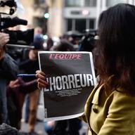 A Sky News journalist holds a French newspaper after a terrorist attack on November 14, 2015 in Paris, France. 