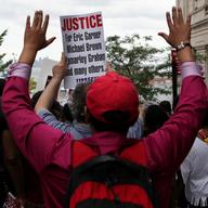 Protestors in Staten Island calling for justice for Eric Garner and police accountability march with their hands up down Bay Street.