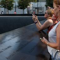 Visitor at the World Trade Center memorial taking photos.