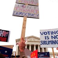 Demonstrators wave signs as they march in front of the US Supreme Court in Washington, DC. December 11, 2000.