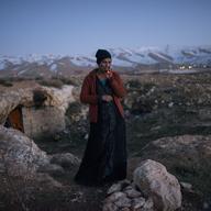 Dalal, 21, a Syrian refugee from the Damascus suburbs stands in front of the cave she and her family have been staying in since crossing into Lebanon roughly a week prior,  in Baalbak, Lebanon.