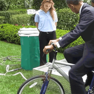 President Obama using a bike-powered water sanitation system at the White House Science Fair