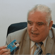 Carlos Davila holds up the 'National Identification' card he manufactures himself and sells for $200.