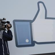 A television photographer shoots the Like sign outside of Facebook headquarters in Menlo Park, Calif., Friday, May 18, 2012.