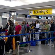 Passengers stand in line at LaGuardia Airport August 29, 2011 in New York.
