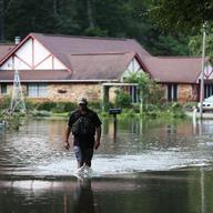 AUGUST 15: Ryan Evans walks along a flooded road on August 15, 2016 in Baton Rouge, Louisiana.