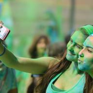 People covered with colorful Gulal powder during the Color Run, a race with party, music and colors in Barcelona city. Catalonia, Europe.