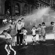 Children cool down in the spray from a fire hydrant during a hot summer on New York's Lower East Side