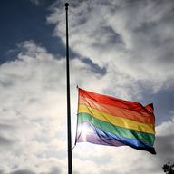 A pride flag stands a half mast during a memorial service in San Diego, California on June 12, 2016, for the victims of the Orlando Nightclub shooting.