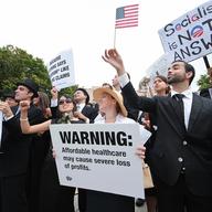 Members of the satirical street theater group 'Billionaires for Healthcare' perform as protesters against Pres. Barack Obama's health care plan and other policies gather in Washington on 9/12/2009. 