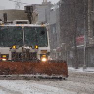 A plow makes its way down 6th Avenue in the West Village.