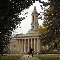 In this Nov. 9, 2017, file photo people walk by Old Main on the Penn State University main campus in State College, Pa.