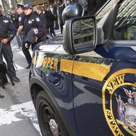 Emergency service personnel with a bomb sniffing dog work outside the building that houses New York Governor Andrew Cuomo's office after a report of a suspicious package, Wednesday