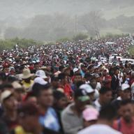 Members of a US-bound migrant caravan stand on a road after federal police briefly blocked their way outside the town of Arriaga, Saturday, Oct. 27, 2018.