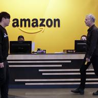 Employees walk through a lobby at Amazon's headquarters Tuesday, Nov. 13, 2018, in Seattle.