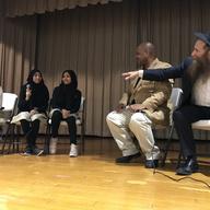 Rabbi Eli Cohen, right, and Geoffrey Davis, center, speak to students at P.S. 289 in Crown Heights.
