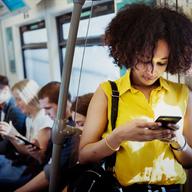 An african american woman on the subway, looking at her phone