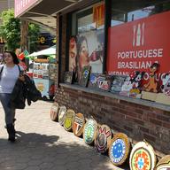 A corner with a Brazilian food cart and soccer team carvings on the street in Newark's Ironbound neighborhood.