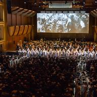 The NY Phil, and Members of the 146-voice chorus dressed as garment workers, in Julia Wolfe's 'Fire In My Mouth'