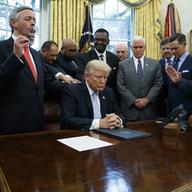 In this Sept. 1, 2017 file photo, religious leaders pray with President Donald Trump after he signed a proclamation for a national day of prayer to occur.