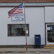 A slightly tattered flag flies outside the Nichols post office Saturday, Jan. 25, 2020, in Nichols, Iowa.