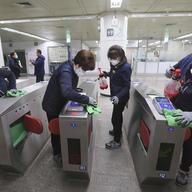 Employees disinfect ticket gates in hopes to prevent the contraction of the coronavirus at a subway station in Seoul, South Korea, Tuesday, Jan. 28, 2020.