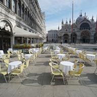 Empty chairs and tables are lined up outside a restaurant in St. Mark's Square in Venice, Italy, Monday, March 9, 2020.