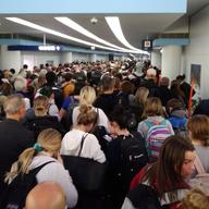 In this Saturday, March 15, 2020, photo, travelers wait in line to go through customs at O'Hare International Airport in Chicago.